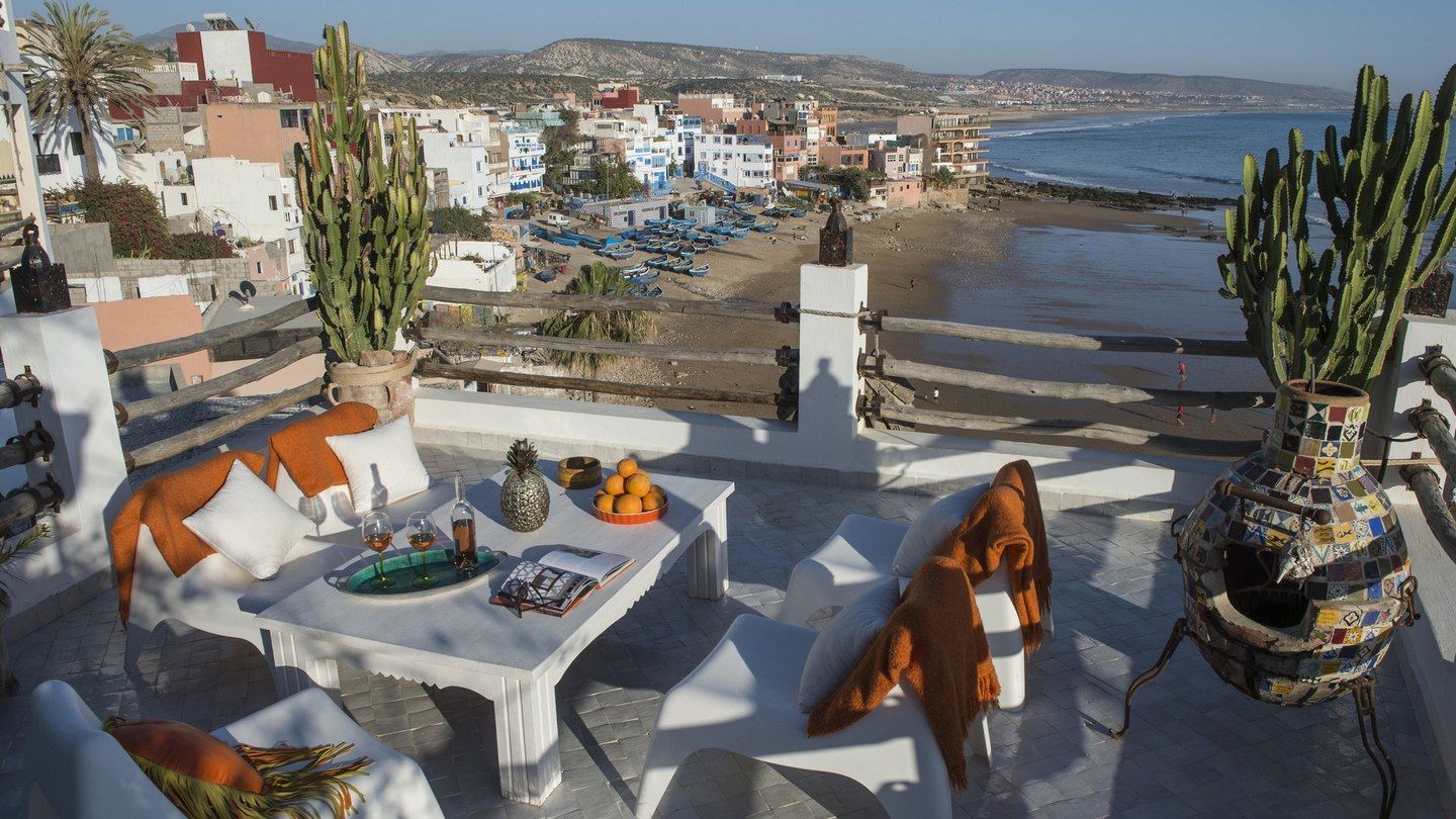 Le rooftop de Munga Guesthouse au coucher du soleil, au-dessus du village de Taghazout et de la baie
